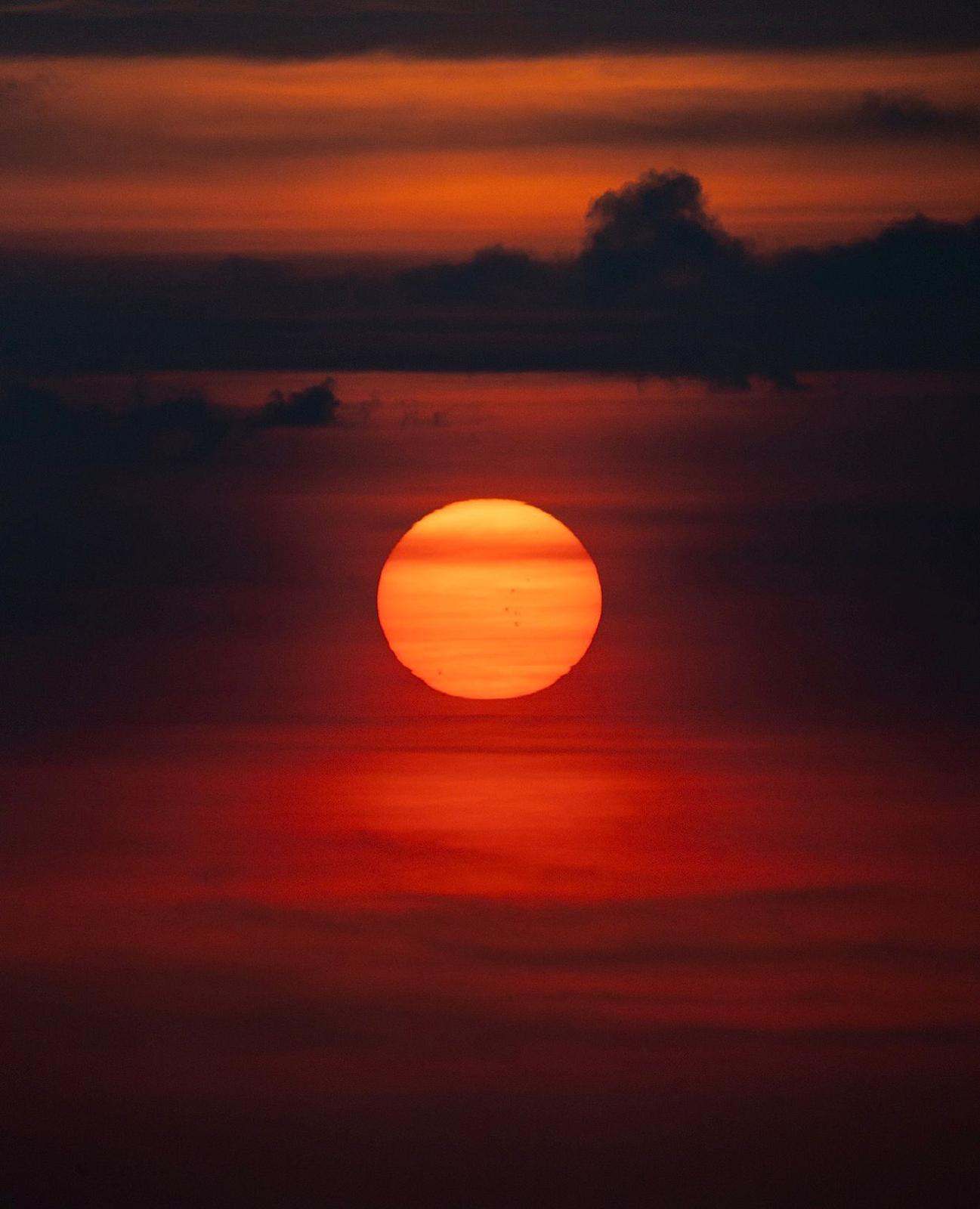 El sol sobre el mar, entre nubes oscuras